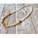 Choker with square brass beads and cream colored rondelle and round shell beads with gold hook clasp